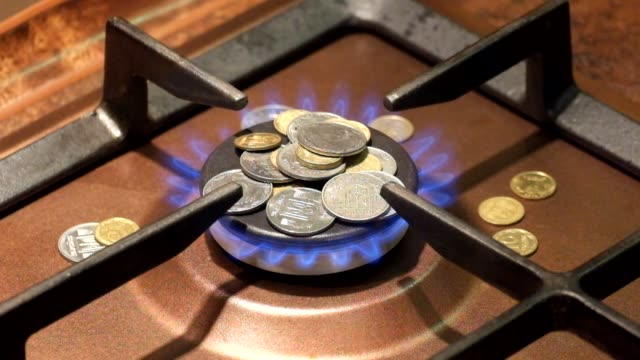 Coins-are-on-a-burning-gas-burner.-Gas-reform-puts-people-on-their-knees
