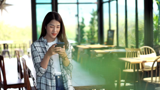 mujer-feliz-usando-un-smartphone-en-un-café
