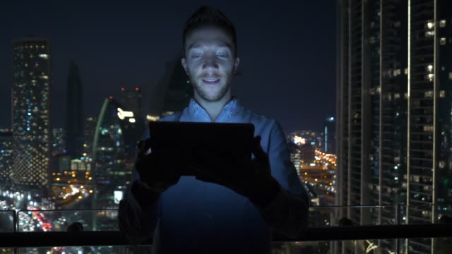 Kaukasischer-Mann,-der-digitales-Tablet-für-das-Internet-und-Kommunikation-mit-Stadtbilding-Hintergrund-nutzt