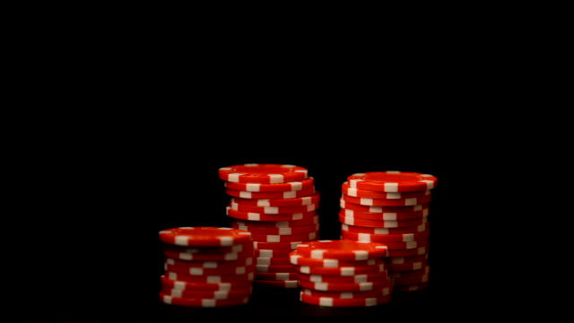 Hand-putting-red-chips-isolated-on-black,-gambling-addiction,-casino-business