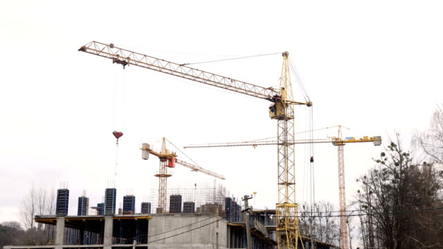 Timelapse-construction-industry.-Three-cranes-and-a-group-of-workers-are-building-a-house.