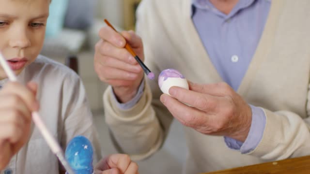 Niño-y-abuelo-decorar-huevos-para-Pascua