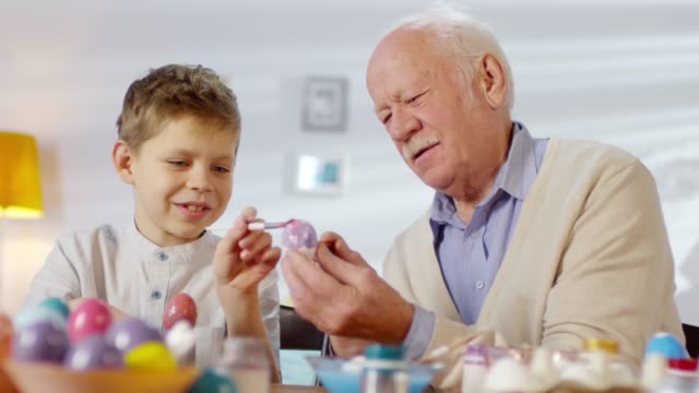 Abuelo-y-nieto-pintando-huevo-juntos