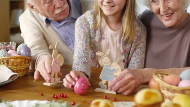 Granddaughter-Playing-with-Grandparents-and-Smiling-at-Easter