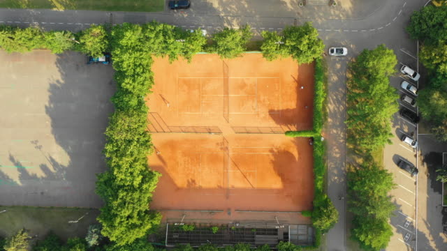 Blick-von-oben-nach-unten-auf-den-öffentlichen-Stadtpark-und-die-Tennisplätze