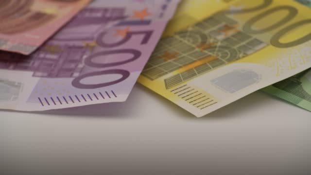 4K-Closeup-of-a-coin-one-euro-with-banknotes-of-different-values.-Cash-money