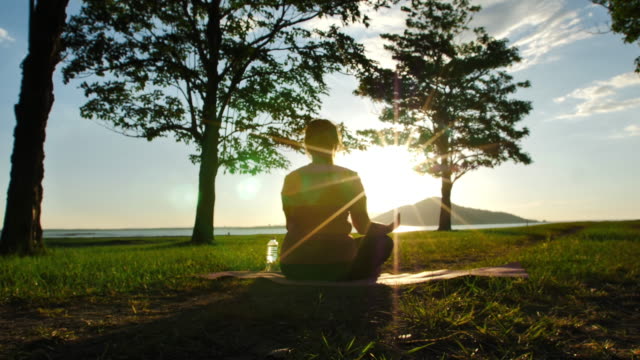 Mujeres-asiáticas-que-practican-yoga-relajarse-en-la-naturaleza-en-la-luz-del-sol-de-la-noche,-Lotus-pos-en-la-sesión-de-meditación.-Fitness-y-concepto-de-estilo-de-vida-saludable.