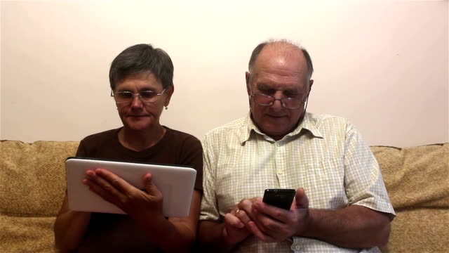 Atractivo-adulto-mujer-y-hombre-adulto-trabajan-en-la-tableta-PC-y-teléfono-inteligente.