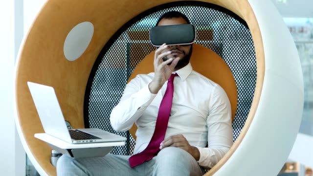 Businessman-using-vr-headset-and-laptop