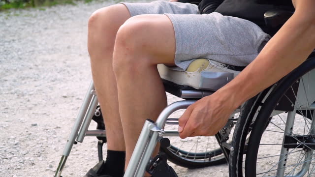 Slowmotion-closeup-of-disabled-young-student-man-in-a-wheelchair