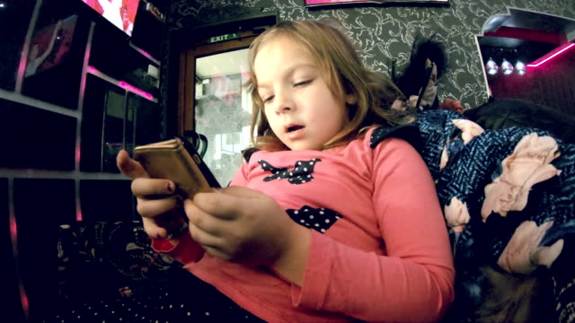 Kleines-Mädchen-beobachten-Cartoon-auf-Smartphone-indoor,-Zeitlupe