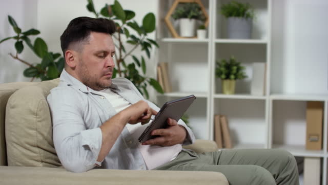 Kaukasischer-Mann-mit-digitaler-Tablet-zu-Hause