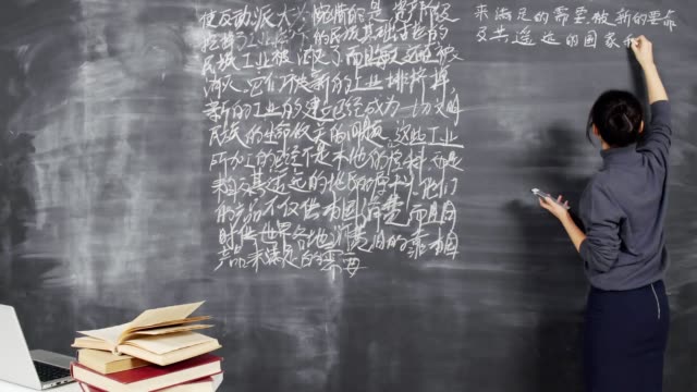 Junge-asiatische-Lehrer-Schreiben-Hieroglyphen-auf-Blackboard
