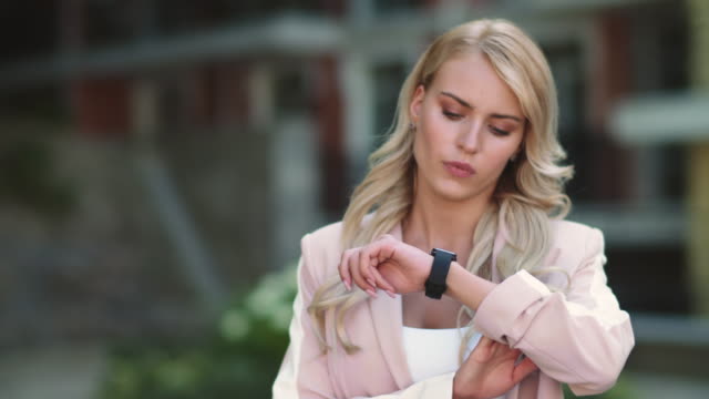 Closeup-business-woman-looking-at-smart-watch.-Woman-looking-at-watch-outdoor