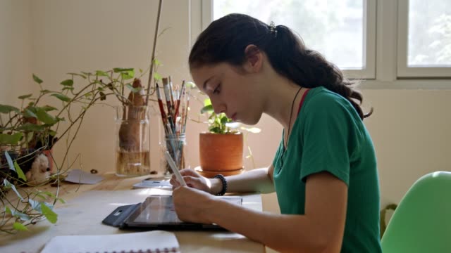 Teenage-girl-drawing-using-a-tablet-computer-and-an-electronic-pen
