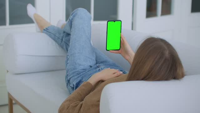Phone-with-Green-Screen-and-Chroma-Key-Closeup.-Chromakey-Mockup-with-Tracking-Markers-and-Alpha-Matte.-POV-is-Vertical-Template-of-Device-in-Modern-House-Closeup.-Scroll-Up-Online-News-at-Cellphone