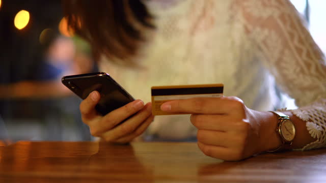 Junge-asiatische-Frau-einkaufen-auf-dem-Handy-mit-Kreditkarte-Zahlung