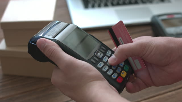 Mano-del-hombre-presionando-el-botón-y-deslizar-tarjeta-de-créditoterminal