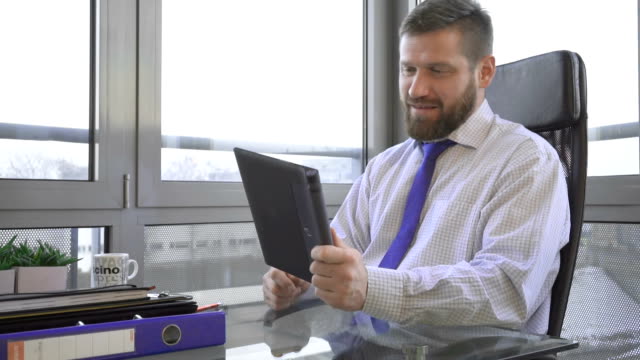 Businessman-taking-video-call,-social-media-on-tablet-app,-office