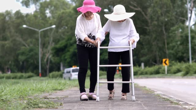 Daughter-take-care-elderly-woman-walking-on-street