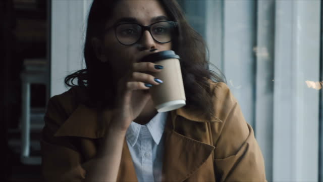 Frau-trinkt-Kaffee-am-Fenster