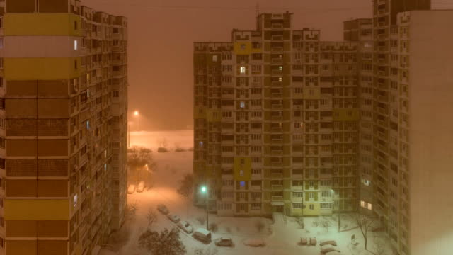 A-snowstorm-in-the-city.-View-from-the-window-to-the-courtyard-at-night.-static-timelapse