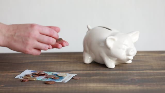Finanzierung-sparen-Konzept.-Geld-im-Sparschwein-Euro-Münzen-werfen