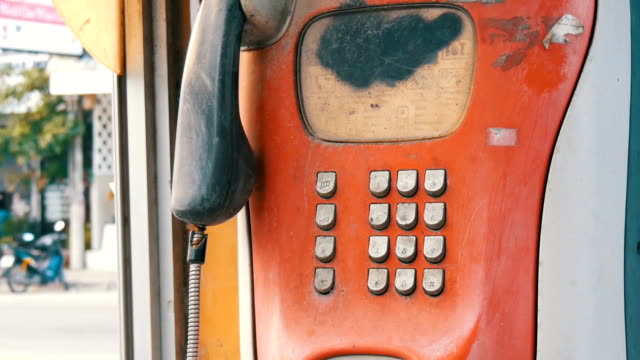 Alten-schäbigen-roten-Telefonapparat-auf-eine-Stadt-Straße.-Vintage-Telefon-in-der-Telefonzelle
