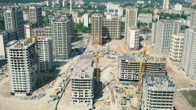 Aerial-view.-Construction-of-a-modern-district-with-residential-apartments-and-developed-infrastructure.-A-construction-site-with-cranes-and-tall-buildings.-Sale-and-rental-of-real-estate
