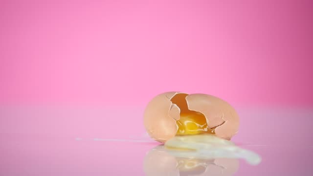 The-egg-falls-and-crashes-on-pink-background