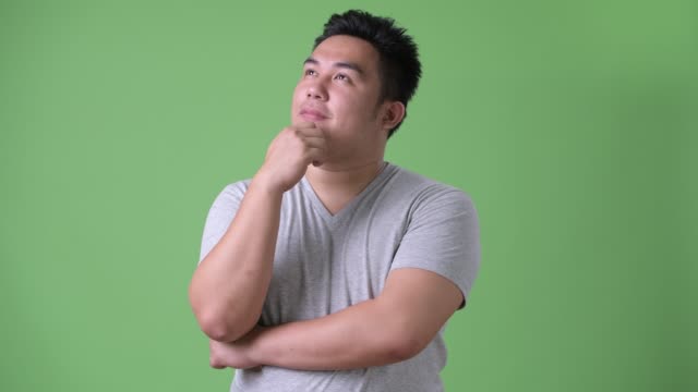Junge-hübsche-Übergewicht-asiatischer-Mann-vor-grünem-Hintergrund