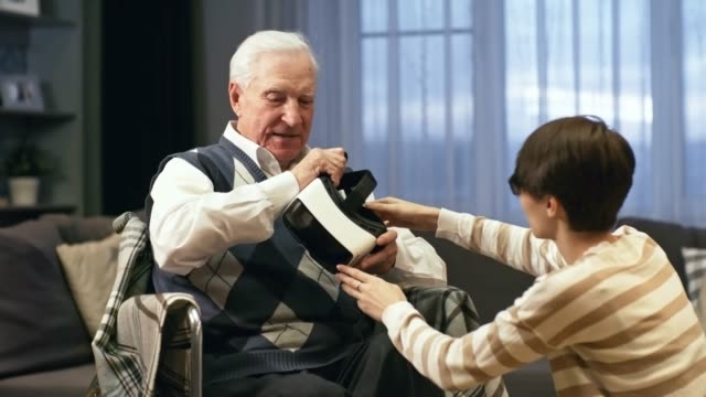 Carer-Helping-Senior-Man-Experience-Virtual-Reality