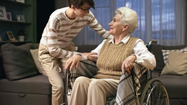 Erwachsenen-Enkelin-posiert-mit-Großmutter-im-Rollstuhl