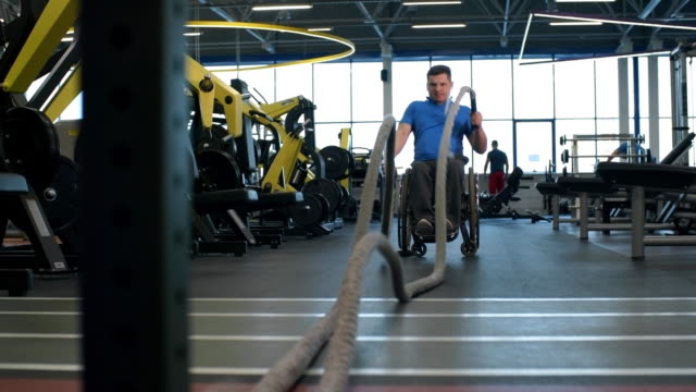 Deportista-en-el-ejercicio-de-la-silla-de-ruedas-con-las-cuerdas-de-la-batalla