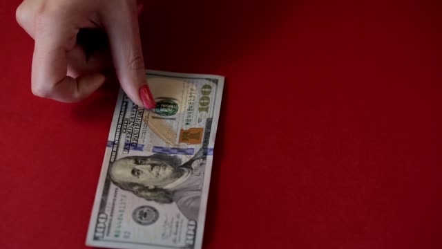 Womanhandchen-mit-roten-Nägeln-schließen-Maniküre-Graf-Hundert-Dollar-Rechnungen.
