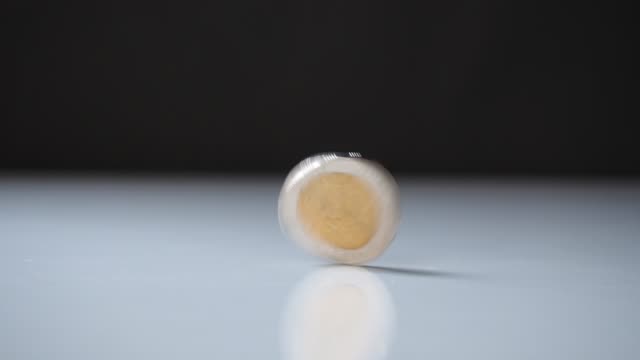 money-coin-rotating-and-spinning-on-white-table.-business-economy-finance-concept.-motion-4k-b-roll-footage