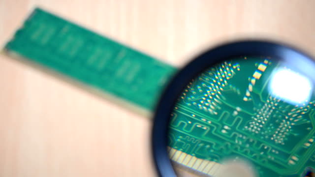 memory-module-examination-with-magnifying-glass.-computer-parts-expertise