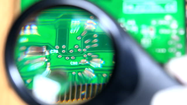 Computer-card-detail-looking-with-magnifying-glass-at-pc-repair-service