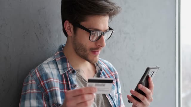 Hombre-usando-tarjeta-de-crédito-para-la-transacción-en-línea
