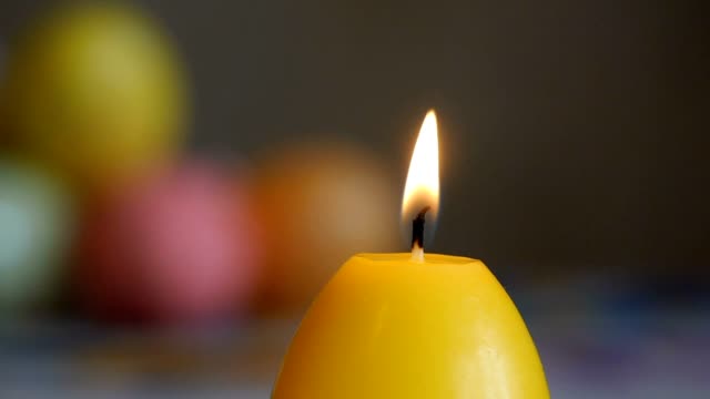 Candles-made-in-shape-of-easter-egg.-Burning-candles.-Yellow-candles-extinguished-from-the-air.