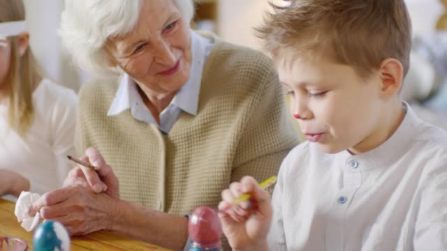 Loving-Grandmother-and-Grandson-Painting-Eggs