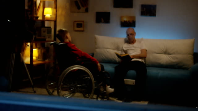 Abuelo-leyendo-a-chico-discapacitado
