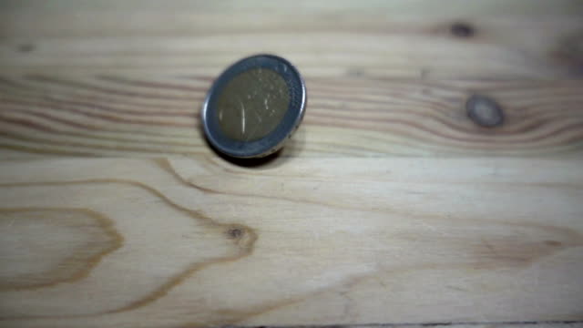 Cámara-lenta-de-rotación-de-monedas-euro-en-una-mesa-de-madera.