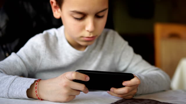 Boy-Play-Spiel-auf-Smartphone,-filmisch-dof
