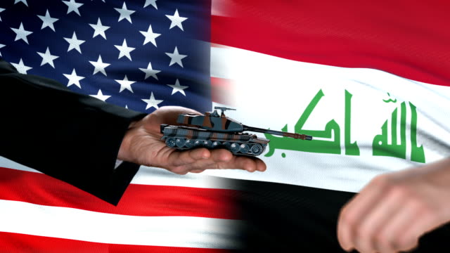 USA-and-Iraq-officials-exchanging-tank-for-money,-flag-background,-partnership