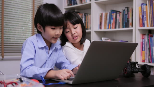 Kleines-Mädchen-und-Junge-mit-Laptop,-um-in-der-Bibliothek-zu-arbeiten.-Konzept-der-Erziehung-und-Lehre.