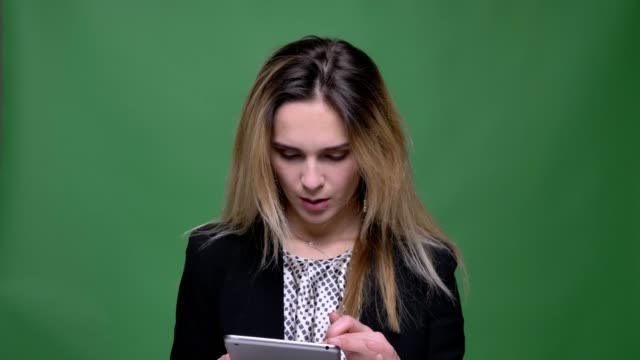 Nahaufnahme-von-jungen-attraktiven-Hipster-kaukasischen-weiblichen-Texten-auf-dem-Tablet-mit-Hintergrund-isoliert-auf-grün