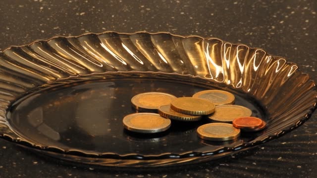 B-roll--footage-of-slowly-zooming-euro-coins-on-a-dark-brown-glass-plate.