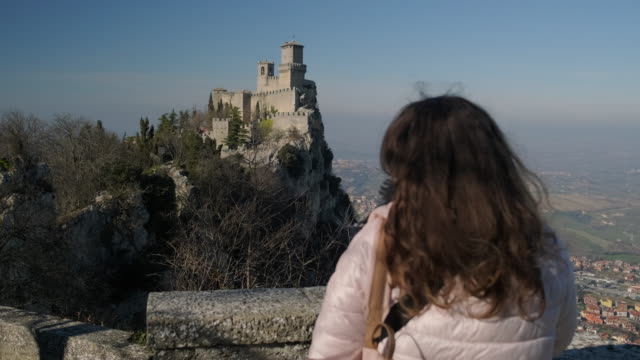 Woman-is-admiring-Guaita-tower-on-mount-Monte-Titano-in-San-Marino