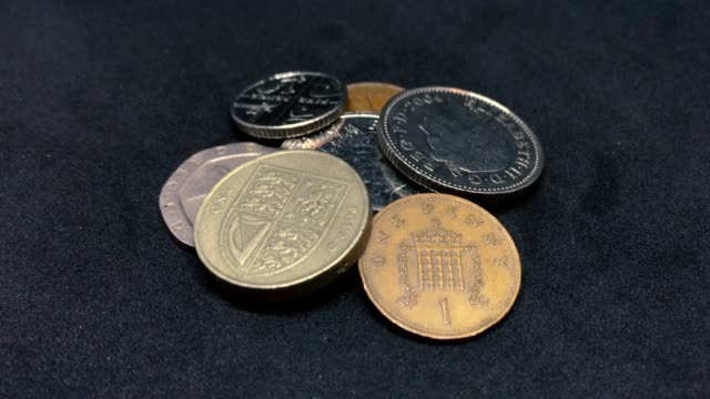 Britische-Pfund-Münzen-drehen-auf-Schwarz---GBP